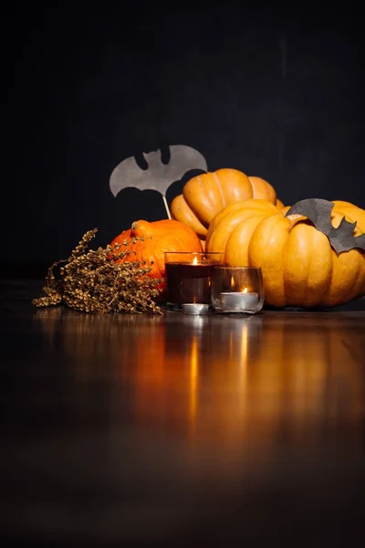 Uma composição para decorar uma casa para halloween, mentir abóboras amarelas e laranja, velas queimam, desenhos de morcegos pretos — Fotografia de Stock