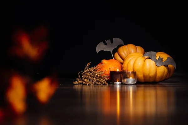 Uma composição para decorar uma casa para halloween, mentir abóboras amarelas e laranja, velas queimam, desenhos de morcegos pretos — Fotografia de Stock