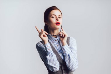 Kırmızı dudaklar bir kızla gözlüklerini alır ve parmağını tarafına işaret ve kameraya doğru görünüyor