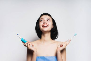 kısa siyah saçlı güzel gülümseyen kız hangi dişlerini fırça fırça seçer: elektronik veya sıradan