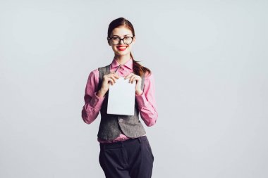 Kızıl saçlı kız gözlük gülümseyen bir parça kağıt elinde tutan ve kameraya doğru görünüyor