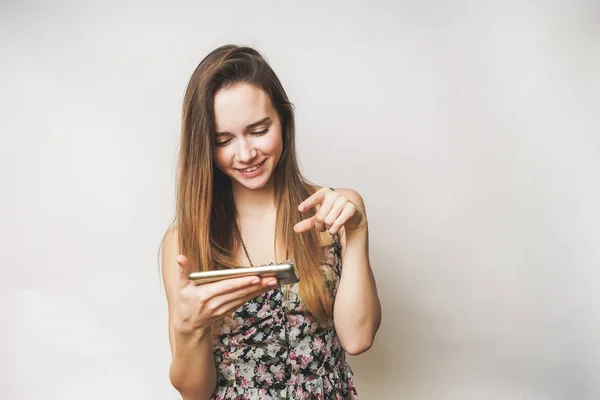 Donna felice utilizzare il telefono cellulare, ragazza dai capelli lunghi in un bel vestito — Foto Stock