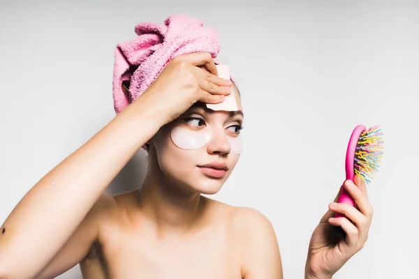 Μετά το ντους με μια ροζ πετσέτα στο κεφάλι της ψάχνουν στον καθρέφτη του μια ροζ χτένα το κορίτσι — Φωτογραφία Αρχείου