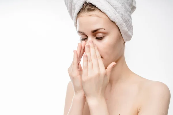 Chica después de la ducha con toalla blanca en la cabeza untado la cara con crema, aislado —  Fotos de Stock