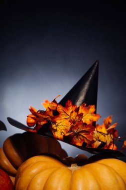 Cadılar Bayramı için bir ev dekorasyon için bir kompozisyon yalan sarı ve turuncu su kabakları, sarı yaprakları ile süslenmiş büyük kara cadı şapka