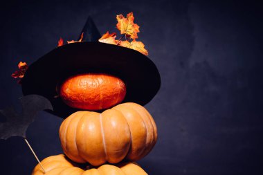 Cadılar Bayramı için bir ev dekorasyon için bir kompozisyon yalan sarı ve turuncu su kabakları, sarı yaprakları ile süslenmiş büyük kara cadı şapka