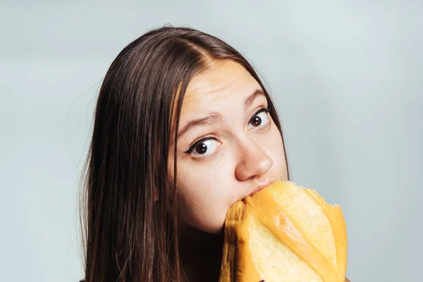 아름 다운 소녀 무게를 잃고 싶어 하지만 열심히 유해한 화이트 빵을 먹는 — 스톡 사진