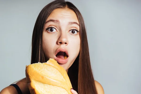 Jovem bonito atlético menina relógios quer perder peso, mas come pão branco prejudicial — Fotografia de Stock