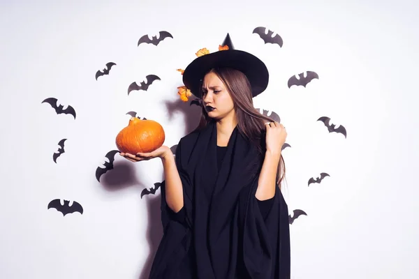 Sexy gothic meisje gekleed in een heks voor Halloween, houden een pompoen — Stockfoto