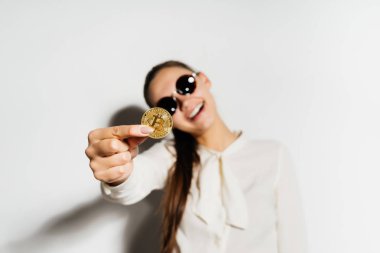 siyah gözlüklü kız bir bitcoin tutuyor