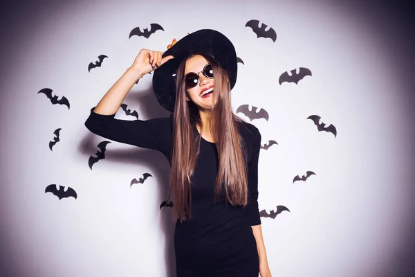 Meisje in een heks kostuum omgeven door vleermuizen — Stockfoto