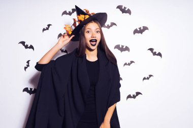 bir kız bir cadının kostüm yarasalar tarafından çevrilidir