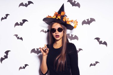 bir cadı gibi giyinmiş bir kız kendini öncesinde bir hedefte bir şey çağrıştırıyor