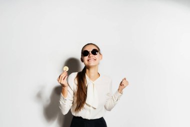siyah gözlüklü bir kız bitcoins birkaç elinde tutuyor
