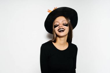 Beyaz bir arka plan üzerinde cadı elbiseli kız