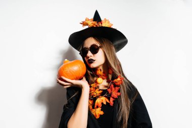 bir kız bir cadının elbiseli küçük bir kabak tutar