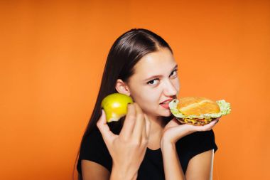 Kız öfkeyle bir elma onu diğer elini tutarak ona burger yiyen