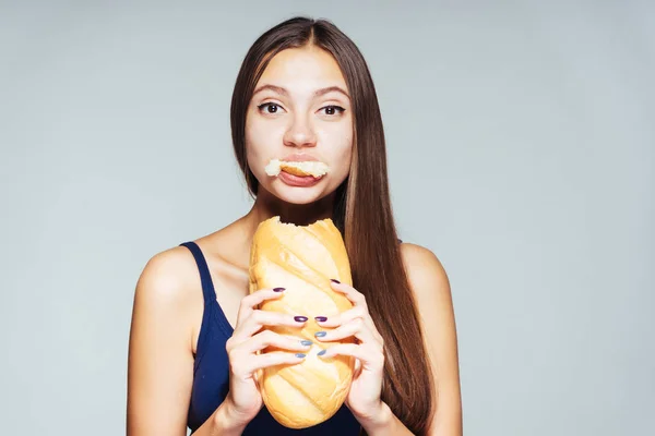 Kız onun elinde büyük bir ekmek yeme mavi tişört — Stok fotoğraf