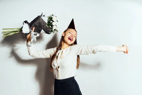 Flicka i en festlig kostym som håller en bukett blommor i hennes händer — Stockfoto