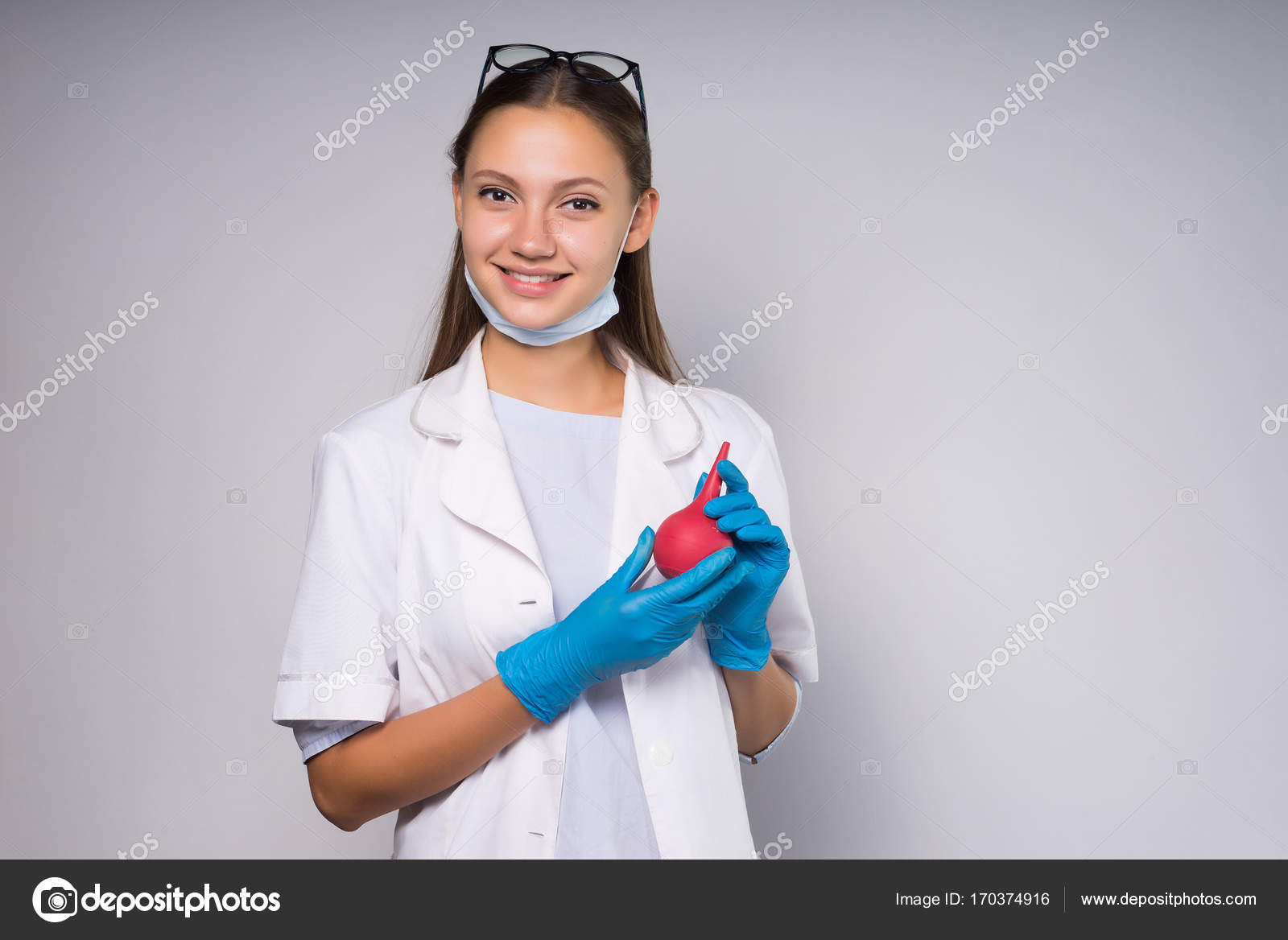 Lovely and beautiful girl in a white lab coat and medical gloves holds