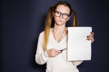 sevimli kız gözlük ile iki ponytails ile A4 kağıda mavi bir arka plan üzerinde izole, işaret