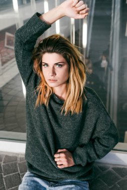 açıklanan saç poz ile trendy bir sıcak kazaklı genç güzel kız