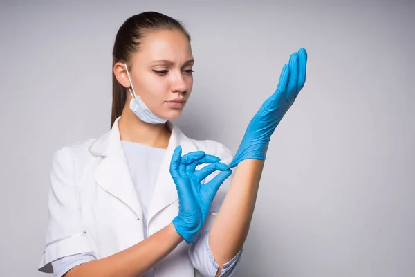 Unga vackra läkare flicka klädd i blå latex medicinska handskar — Stockfoto