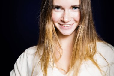 Kameraya bakarak mavi gözlü genç gülümseyen güzel kız