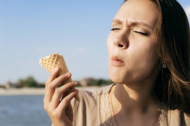 dondurma yeme bir genç kız, onu içinde parlayan güneş yüz ve o gözleri kapalı