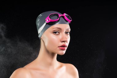 genç güzel kız bir yüzme kap ve gözlük siyah duvar arka plan üzerinde duruyor