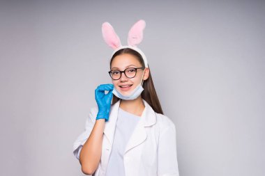 gözlük ve tıbbi bir önlük giyen genç güzel kız tavşan kulağı, şeklinde bir RIM ile gülümseyen