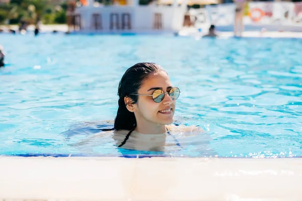 Giovane ragazza felice in occhiali da sole nuotare in piscina — Foto Stock