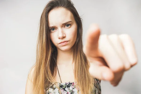 Jovem menina forte com cabelos longos mostra um dedo na câmera — Fotografia de Stock