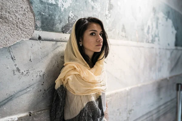 Portrait of a thoughtful sad girl in a headscarf on the head of the light sitting in the temple, praying — Stock Photo, Image