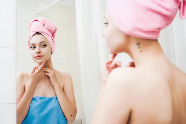 Młoda piękna dziewczyna z różowy ręcznik na głowie wygląda na siebie w lustrze — Zdjęcie stockowe