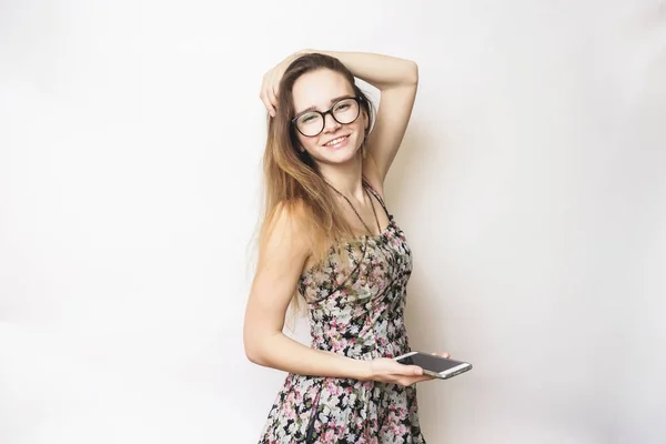 Giovane ragazza felice sorridente con gli occhiali sta tenendo un telefono — Foto Stock