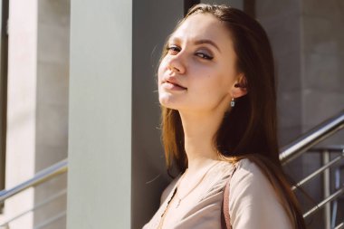 Güneşte ayakta ve poz bir bej elbise genç güzel kız