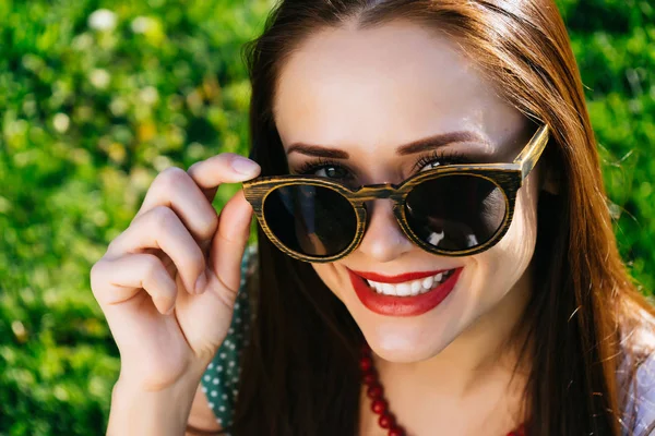 Donna in occhiali, ragazza con gli occhiali da sole, copyspacesits su erba verde — Foto Stock