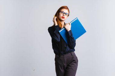 seksi kırmızı saçlı kız gözlüklü ve kameraya bakarak ve belgelerle izole mavi bir dosyayı tutan kırmızı dudaklar