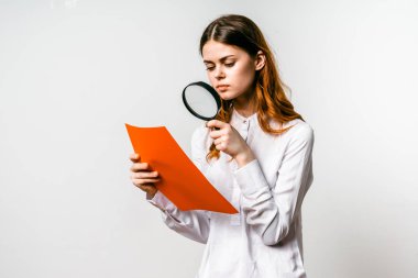 bir kız büyük beyaz gömlekli Büyüteç camı izole turuncu sayfa a4 üzerinde görünüyor.