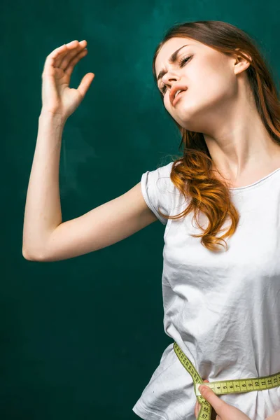 A rapariga está a medir a cintura e a levantar a mão. mulher triste, dieta, emagrecimento, corpo bonito — Fotografia de Stock