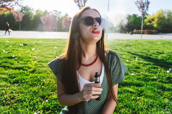 Felice moda sorridente Donna in occhiali da sole fumo vaporizzatore sulla strada, fumo — Foto Stock