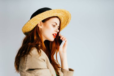 yeşil bir bluz ve büyük bir şapka garip bir kız bir cep telefonu tutuyor ve tepeden bakıyor