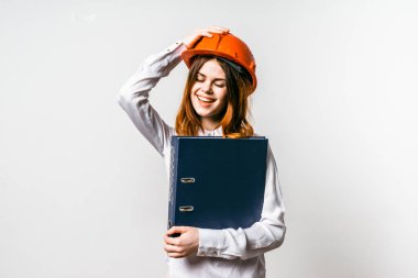 sevimli kız portakal kask içinde ve büyük eller klasöründe ile. Gerl onun el ve kahkaha ile onun kask tutar