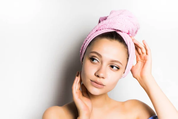 Hermosa chica después de una ducha con una toalla de color rosa en la cabeza parece misteriosamente a un lado. hermosa mujer — Foto de Stock
