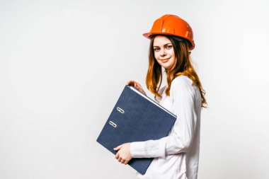 belgelerle ve turuncu bir kask içinde büyük bir klasörle kız gülümsüyor ve izole kameraya benziyor
