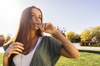 Mutlu gülümseyen kadın rahatlatıcı açık, özgürlük kavramı, yeşil çim çevresinde