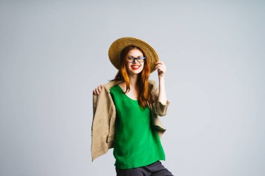 genç bir hasır şapka, yeşil ceket ve gözlük gülmek güzel