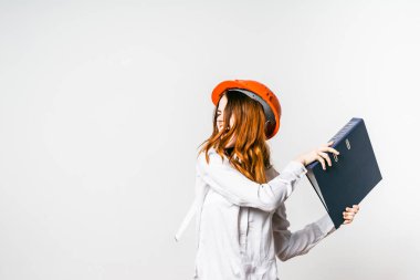 Kızıl saçlı kız çığlık ve kağıtları ile klasör atma turuncu koruyucu kask içinde