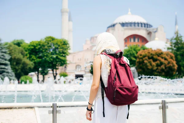 An unrecognizable woman in a scarf with a backpack on the background of Aya Sofia and a fountain. Summer vacation, traveler — Stock Photo, Image